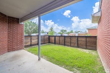 the backyard of a house with a fence and a patio